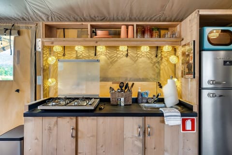 4 burner propane cooktop featuring an apartment sized fridge and retro microwave.