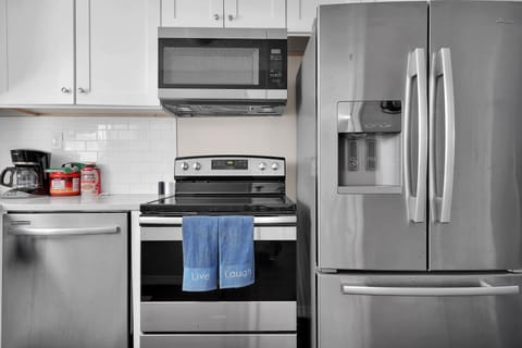 Kitchen w/ plates, bowls, cups, coffee, dishwasher, microwave, pots & pans