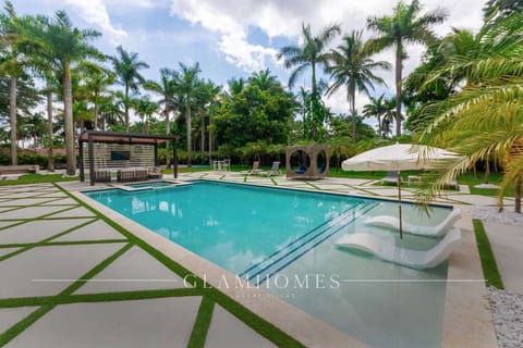 Resort-style pool surrounded by lush palm trees, modern loungers, and open green spaces. A private oasis designed for relaxation, sun-soaked days, and unforgettable memories.