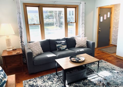 Large picture window overlooks the front porch on a quiet residential street