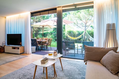 Bright open-plan living room with garden views — Home Six Troia, holiday villa in Grândola