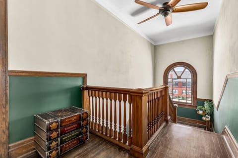 Third floor landing featuring hardwood floors over 100 years old, lead glass windows, and antique decor.