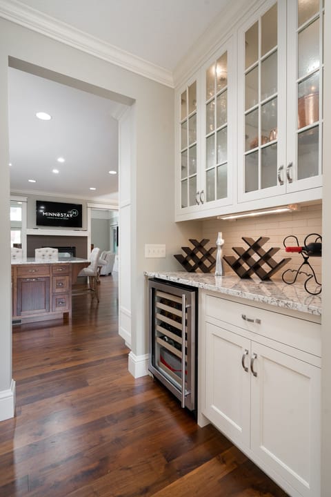 Your elegant butler's pantry features glass-front cabinetry, wine storage, and granite countertops - perfect for entertaining.