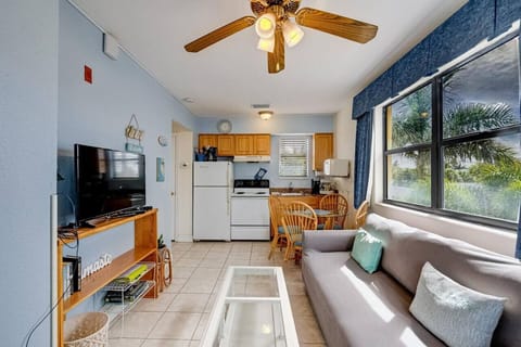 Bright living area w/ comfy seating, TV, and large windows that fill the space with natural light.