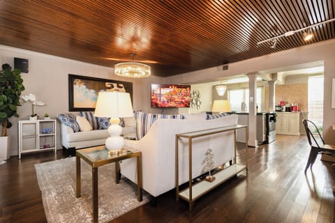 Spacious open-plan living and dining area with statement lighting and rich wood ceilings that bring warmth and sophistication.