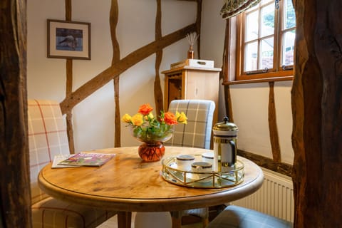 Table with four comfy chairs and a cottage window overlooking the courtyard