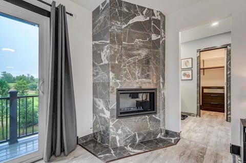 The master bedroom features a private balcony and a fireplace that is exquisitely tiled.