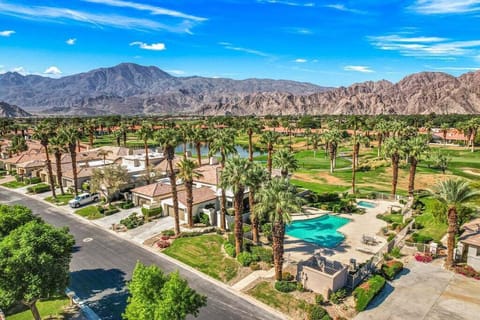 Drone view of Casa Lily condo, community pool, golf course, and mountains