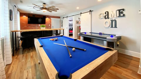 Game room features a pool table and an air hockey table