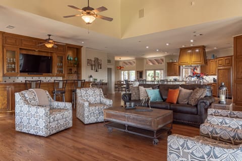 Wet bar and living room with 55" TV in bar as well as a 80" TV in living room