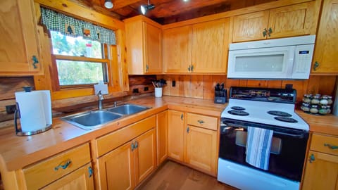 Full Kitchen stocked with dishes, pots, pans, silverware, and utensils. 