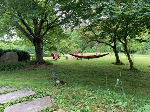 Front porch looks over back fields. Relax in hammocks and chairs with firepit.