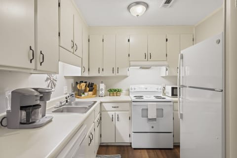 The classical all-white kitchen is well equipped.