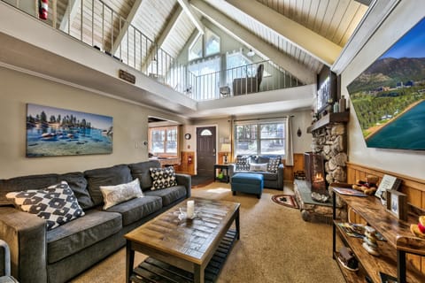 You'll love unwinding in this spacious living room with soaring ceilings, cozy fireplace, and comfortable seating perfect for gathering with loved ones.
