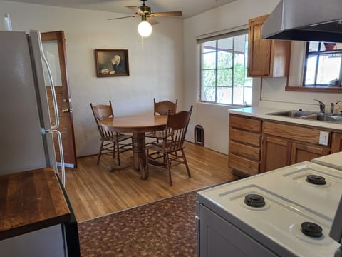 From hallway, shows kitchen & dining room which seats 4 & a view of back patio.