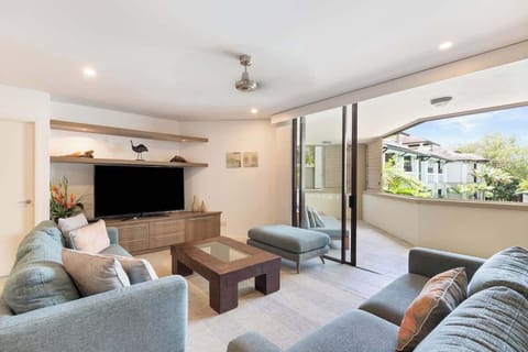 Unwind in the spacious open-plan lounge, complete with plush seating, ceiling fan, and seamless flow to the breezy balcony.
