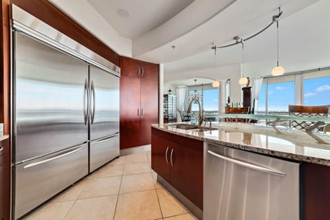 Gourmet kitchen with stainless steel appliances, granite countertops, and island seating. Open floor plan seamlessly connects to the living and dining areas.