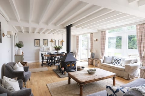 The Coach House - open plan sitting room with central wood burning stove