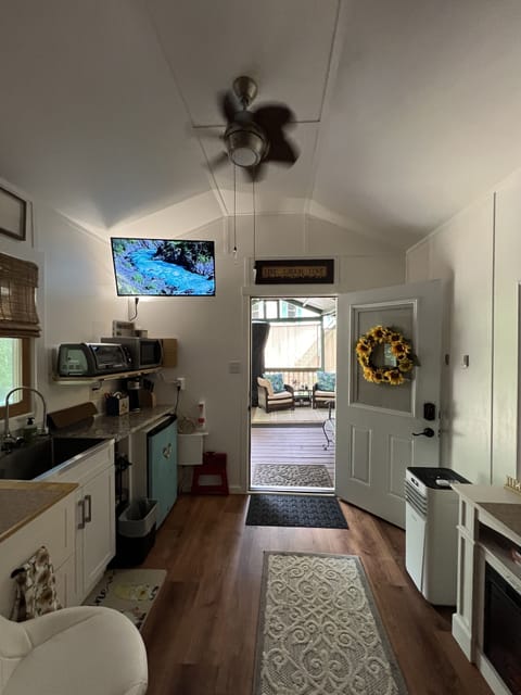 View from bedroom area see kitchen, door open to see outdoor seating area.