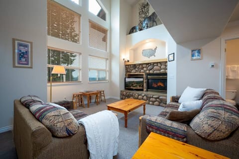 Relax by the fireplace in a sun-filled lodge-style living room after a day on the slopes.