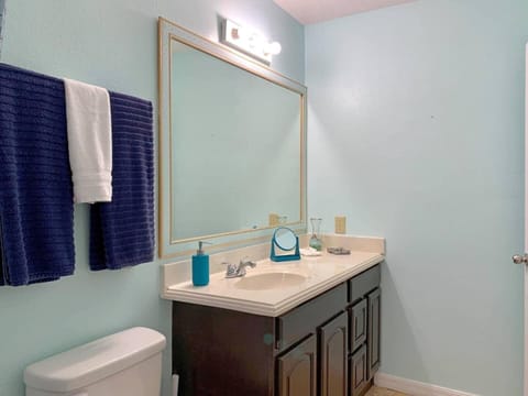 Bathroom vanity with washbasin, mirror, hand soap and cloth towels