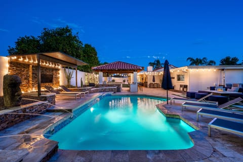 Pool Area w/ Several Sun Beds, Pristine Water, and Blue Skies.