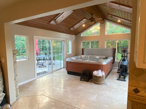 Inviting hot tub overlooking patio with BBQ, fire pit and outside seating.