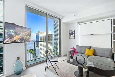 Living/sleeping area w/ view of Biscayne Bay Port - This cozy living space is perfect for family movie nights and lazy weekends. The large windows afford you panoramic views of the city.