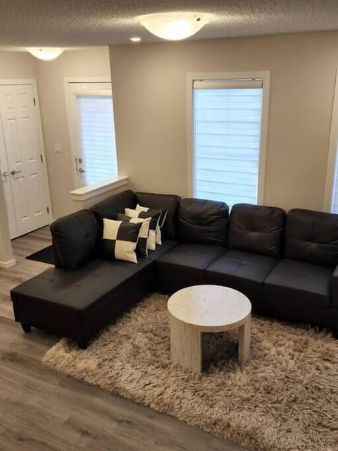 Open-concept living room features a large L shape sofa and Small Cushions with a Small Coffee Table