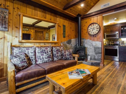 Living room and adjacent kitchen: gas fireplace, air conditioner, hard floors, kitchen with stainless steel appliances, custom made cabinets and granite counter-tops.