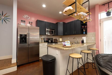 Sassy meets stylish in this fully equipped kitchen with black cabinetry, granite counters, and whimsical pink-and-white cowgirl hat accents. Whether you’re cooking or just pouring champagne, it’s all part of the fun