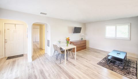 View from entry showing living room, queen pull out sofa, smart TV and dining table.
