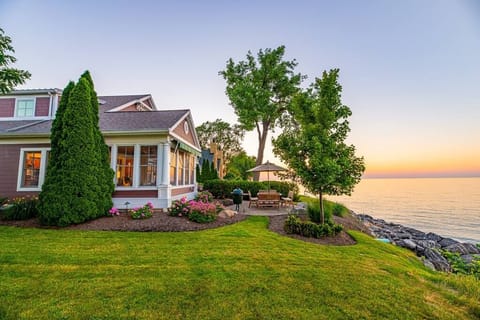 East side rear of the home and outdoor dining area looking to the west from the neighbors yard