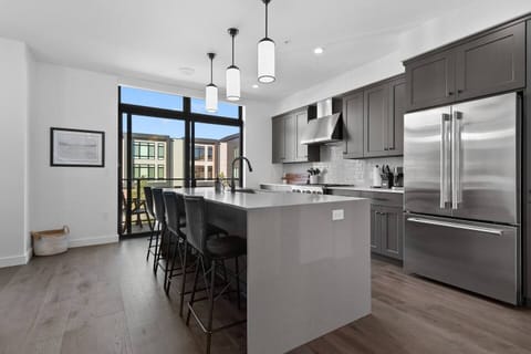 The second floor features an open concept kitchen with gourmet appliances, patio with teak dining set, walk-in pantry and formal dining area as well as an adjacent living room area with a gas fire place and wet bar.