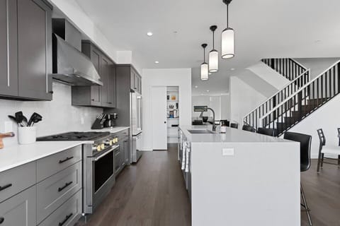 The second floor features an open concept kitchen with gourmet appliances, patio with teak dining set, walk-in pantry and formal dining area as well as an adjacent living room area with a gas fire place and wet bar.