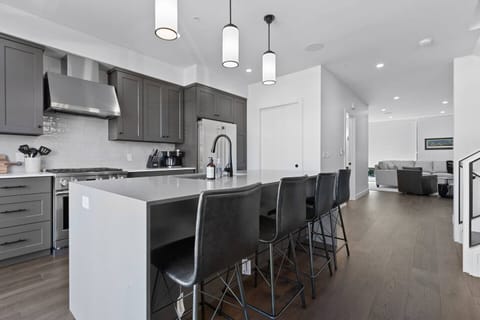 The second floor features an open concept kitchen with gourmet appliances, patio with teak dining set, walk-in pantry and formal dining area as well as an adjacent living room area with a gas fire place and wet bar.