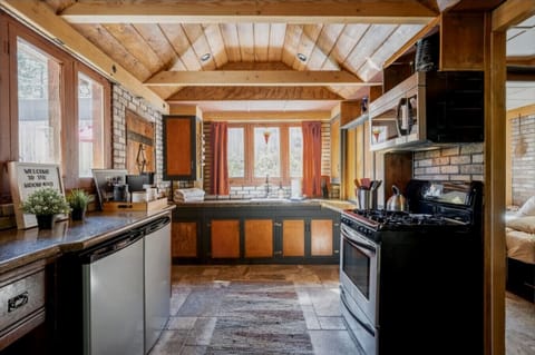 Bright and inviting cabin kitchen with wooden ceilings, modern appliances, (Two mini-refrigerators) and a cozy window view, making meal prep a delight in this rustic retreat.Two mini-refrigerators