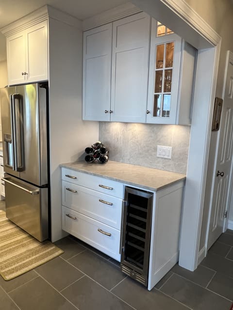 Full bar station with glass ware and mixology tools.  Wine cooler and rack.