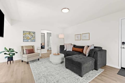 Relax in this cozy, modern living room featuring a plush sectional, chic decor, and inviting natural light—perfect for unwinding after a day of exploring.