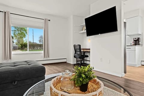 Bright and modern living space with cozy seating, smart TV, and dedicated workspace—perfect for relaxing or working remotely.