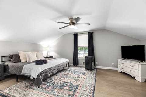 Luxurious King Suite featuring high-quality linens and a cozy ceiling fan for added comfort.