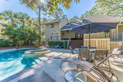 The pool area is a true gem, featuring outdoor dining, a grill, lounge chairs, and a large swimming pool with a hot tub.