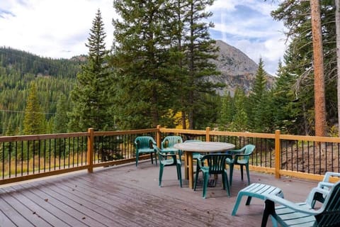 An exterior view of the outdoor deck with a peaceful mountain setting where you can melt your cares away among the pines.
