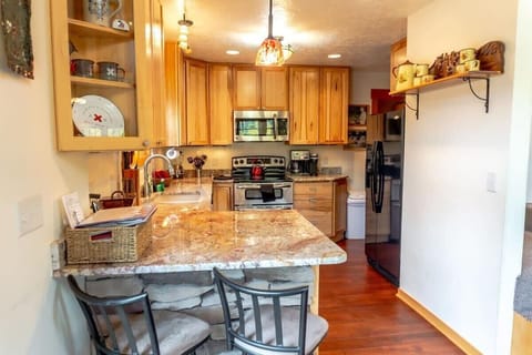 The view into the kitchen from the dining room highlight’s the home’s open-concept layout perfect for easy socializing. Serve your guests at the bar and take in the incredible view while enjoying dinner!
