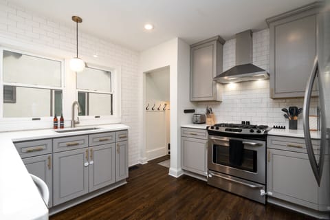 Cook your favorite meals in this stylish kitchen with modern gray cabinets, stainless steel appliances, and bright subway tile backsplash.
