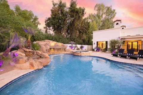 Indulge in an evening swim beneath a painted sky and glowing palms.