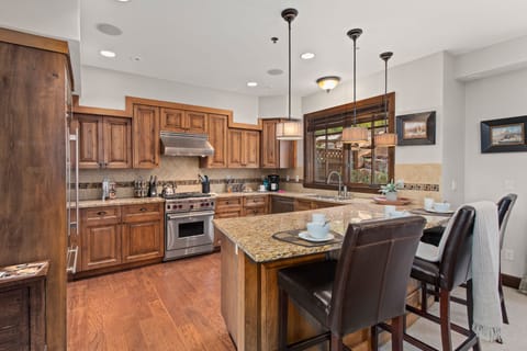 Fully Equipped Kitchen with beautiful stone countertops, stainless steel Wolf appliances, sub zero fridge, and bar seating for 3