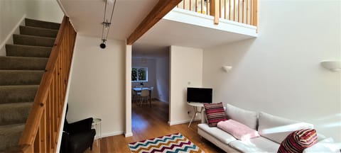 Downstairs, showing living room stairs and balcony.