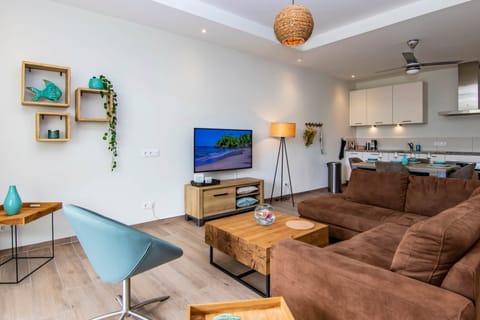 Lounge set with 50 inch smart TV in the living room with open kitchen. (1)