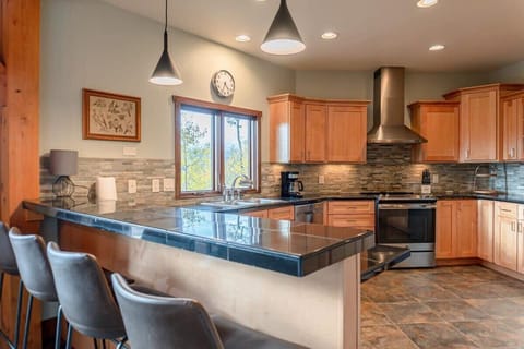 The fully equipped kitchen with a bar area that seats up to four, this space serves as an ideal bridge between the dining area and the kitchen.
